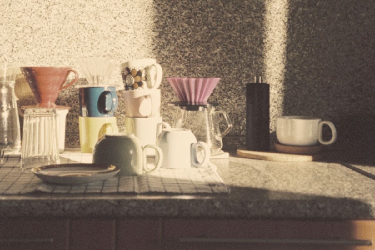 Morning sun across a café counter with mugs and pour-over gear
